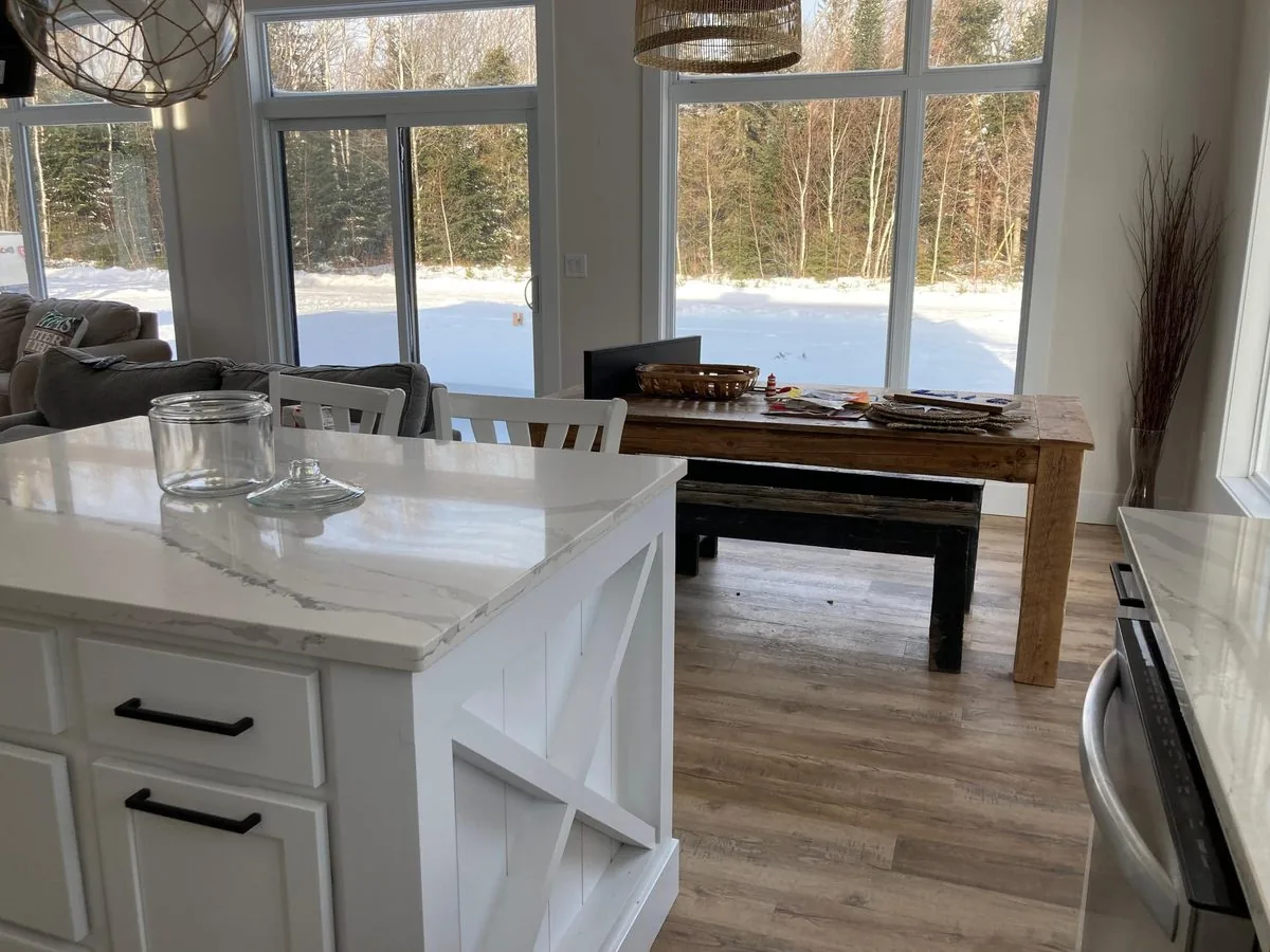 The kitchen island and harvest dining table looking toward the tall front windows
