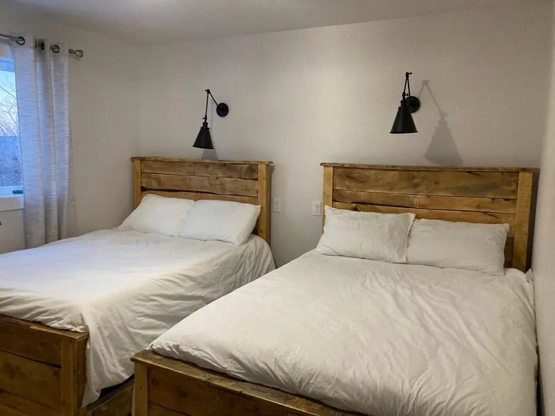 The upstairs bedroom with two double beds and wall lamps