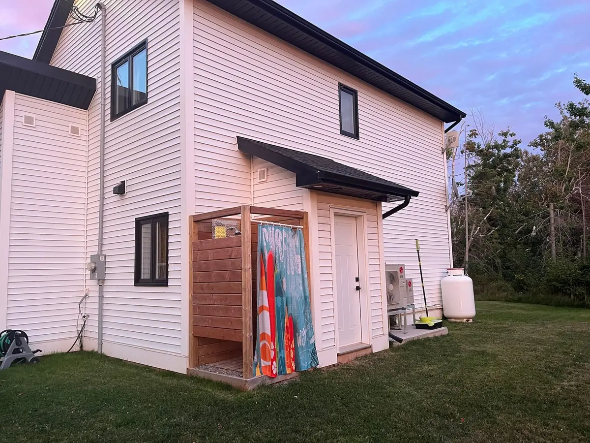 The outdoor shower behind its surfboard-print screen on the side of the cottage