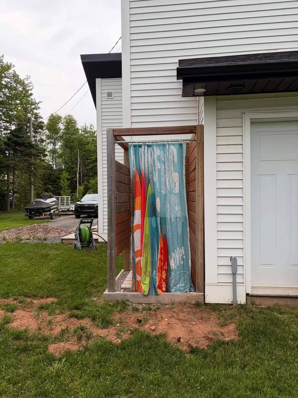A closer look at the outdoor shower and its surfboard-print curtain
